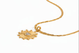 Gold necklace with heart-shaped pendant on a white background
